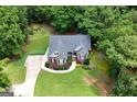 Aerial view of a beautiful single-story home with lush landscaping surrounded by mature trees at 172 Sam Solomon Rd, Locust Grove, GA 30248