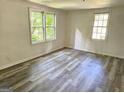 Bright bedroom featuring new grey wood flooring and natural light streaming through the windows at 602 Mccurdy Rd, Villa Rica, GA 30180