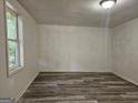 View of an empty room featuring new wood flooring, clean windows, and freshly painted walls at 602 Mccurdy Rd, Villa Rica, GA 30180