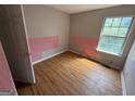 Cozy bedroom with wood floors, natural light and a unique accent wall, a blank canvas awaiting your personal style at 2355 Burdett Ridge Dr, South Fulton, GA 30349