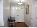 Welcoming foyer with elegant double doors, hardwood floors, light fixture, and stylish decor that create a warm entrance at 1310 Larkview Sw Dr, Lilburn, GA 30047