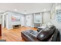 Inviting living room featuring hardwood floors, natural light, neutral paint, and an entertainment center at 456 Pretty View Se Ln, Smyrna, GA 30082
