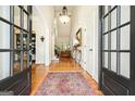 Stunning foyer with dark wood floors, chandelier, and an ornate rug leading into an open living space at 6017 Chestatee Creek Nw Ct, Acworth, GA 30101