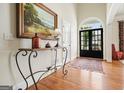 Beautiful foyer with dark wood floors, an ornate wrought iron table, and black framed front door at 6017 Chestatee Creek Nw Ct, Acworth, GA 30101