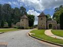 Picturesque community entrance featuring stone gatehouses, well-maintained landscaping, and welcoming signage at 4309 Giverny Blvd, Fairburn, GA 30213