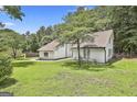Well-maintained home with a green lawn and mature trees, offering curb appeal and a serene setting at 205 Shadowood Ln, Peachtree City, GA 30269