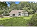 Beautiful home with a lush green lawn, framed by mature trees and a welcoming entrance at 205 Shadowood Ln, Peachtree City, GA 30269