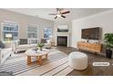 Staged living room with lots of windows, a fireplace, hardwood floors, and neutral decor at 36 Crescent Chase, Dallas, GA 30157