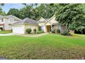Charming home featuring a well-manicured lawn, mature trees, and a welcoming entrance at 1335 Vine Cir, Mcdonough, GA 30253