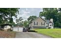 Spacious home exterior with a driveway, detached garage, and metal carport perfect for extra storage at 565 Scarborough Rd, Ellenwood, GA 30294