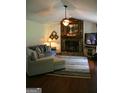 Cozy living room features a stone fireplace, ceiling fan, neutral walls, and comfortable furniture at 565 Scarborough Rd, Ellenwood, GA 30294