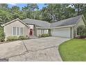 Stunning home with a two-car garage, beautiful landscaping, and a striking red front door at 118 Whitfield Run, Peachtree City, GA 30269