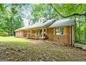 Charming brick home with a front porch and inviting curb appeal nestled among mature trees at 1290 Shadowlawn Ne Dr, Conyers, GA 30012