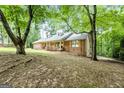 Charming brick home with a front porch and inviting curb appeal nestled among mature trees at 1290 Shadowlawn Ne Dr, Conyers, GA 30012