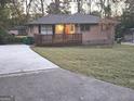 Inviting home with a spacious driveway and a charming wooden deck overlooking the well-manicured front lawn at 655 Shellnut Dr, Forest Park, GA 30297