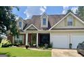 Traditional home with dormer windows, a two-car garage, green shutters, and a landscaped front yard at 221 Turtle Cv, Carrollton, GA 30116