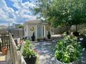 Garden shed amongst the trees with a gravel yard, and butterfly decorations at 221 Turtle Cv, Carrollton, GA 30116
