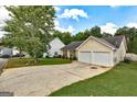 A quaint home features a two-car garage, tidy landscaping, and a well-maintained lawn at 2898 Cedar Trace Dr, Ellenwood, GA 30294