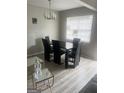 Contemporary dining area with a sleek black table, chairs, and modern chandelier at 2511 Pine Tree Trail, Atlanta, GA 30349