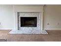 Close-up of a traditional fireplace with a white marble surround and hearth at 133 Magazine St, Dallas, GA 30157