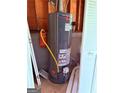 A gray Rheem water heater stands against a wood wall with white doors next to it at 133 Magazine St, Dallas, GA 30157