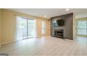 Open living room with balcony access, a fireplace, and views into the kitchen and dining area, featuring light floors at 1102 Wynnes Ridge Cir, Marietta, GA 30067