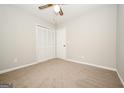Neutral bedroom featuring a ceiling fan and spacious closet, perfect for relaxation at 6194 Golden Meadow Court Ct, Riverdale, GA 30296