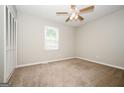 Bright bedroom with neutral decor, a ceiling fan, and a view from the window at 6194 Golden Meadow Court Ct, Riverdale, GA 30296
