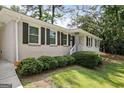 Attractive single-story home displaying a white brick exterior, dark shutters, and lush landscaping at 2855 Briarlake Ne Rd, Atlanta, GA 30345