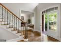 Elegant foyer with hardwood floors, staircase with iron spindles, and a glimpse into the bright living room at 125 Franklin Pl, Atlanta, GA 30342