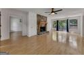 Bright living room with hardwood floors, stone fireplace, and sliding doors to the outside deck at 178 Castleair Ne Dr, Kennesaw, GA 30144