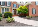 Inviting entrance featuring brick facade, covered porch, and lush landscaping detail at 3045 Moss Stone Lane Sw Ln, Marietta, GA 30064