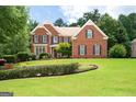 Charming brick two-story home with manicured lawn and decorative landscaping at 3045 Moss Stone Lane Sw Ln, Marietta, GA 30064