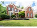 Brick two-story home with manicured lawn and attractive landscaping, showcasing curb appeal at 3045 Moss Stone Lane Sw Ln, Marietta, GA 30064
