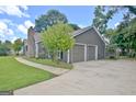 Features a two-car garage with a concrete driveway and well-maintained lawn at 110 Chesterfield Ct, Fayetteville, GA 30214