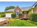Charming entrance with wooden porch, brick accents, and well-maintained landscaping at 180 Moseley Crossing Dr, Stockbridge, GA 30281