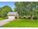 Charming single Gathering home with a well-manicured front yard and brick facade at 180 Moseley Crossing Dr, Stockbridge, GA 30281