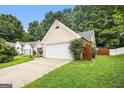 Cozy one-story home featuring a two-car garage, a driveway, and a green lawn at 1055 Avalon Dr, Lawrenceville, GA 30044