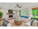 Inviting living room with a cozy fireplace, plush seating, and abundant natural light, ideal for relaxation and entertainment at 115 Edgewater Way, Peachtree City, GA 30269
