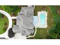 Aerial view of a large home with a pool, spa, pergola, screened in porch, and lush green backyard at 310 Westbourne Dr, Tyrone, GA 30290