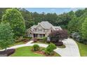 Beautiful brick two-story home with lush landscaping and a circular driveway at 310 Westbourne Dr, Tyrone, GA 30290