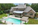 An aerial view of a pool, spa, screened in porch, pergola, and well manicured backyard at 310 Westbourne Dr, Tyrone, GA 30290