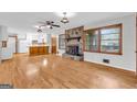 Spacious living room featuring hardwood floors, stone fireplace, and natural light, creating a warm and inviting atmosphere at 1189 E Fayetteville Rd, Riverdale, GA 30296
