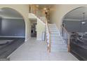 Bright foyer with staircase, tile flooring, and open arches leading to other living spaces at 176 Fairoaks Cir, Stockbridge, GA 30281