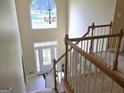 View from the top of staircase to front door with arched window and modern chandelier at 176 Fairoaks Cir, Stockbridge, GA 30281