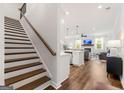 View of the open floor plan featuring a staircase, living room, kitchen, and hardwood floors at 1316 Willamette Way, Marietta, GA 30008