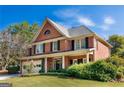 Beautiful two-story brick home with lush landscaping, front lawn and a two-car garage at 4729 Woodland Brook Se Ct, Atlanta, GA 30339
