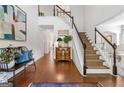 Welcoming foyer with hardwood floors, staircase, bench seating, and stylish decor at 4729 Woodland Brook Se Ct, Atlanta, GA 30339