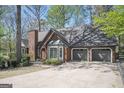 A view of the right side of the home with a large driveway leading to a three car garage at 2689 Spring Rock Ne Ct, Roswell, GA 30075