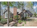 Beautiful brick home with a large chimney, bay windows, and mature trees surrounding the property at 2689 Spring Rock Ne Ct, Roswell, GA 30075
